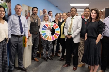 CAWST team standing, with one woman holding the UNSDGs sign