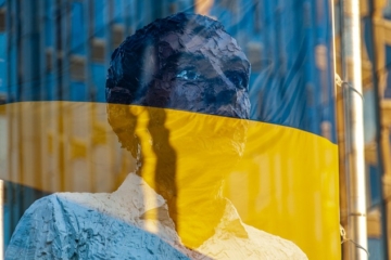 Ukraine flag with sculpture in the background